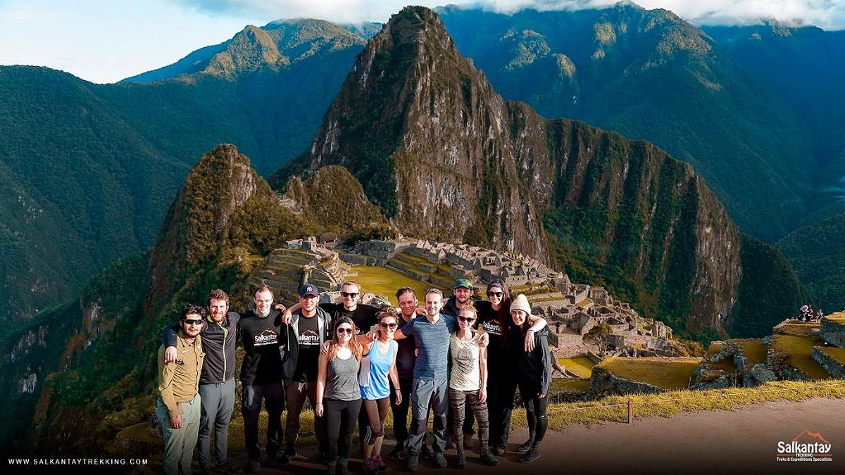 Group of tourists posing for a photo with Machu Picchu in the background