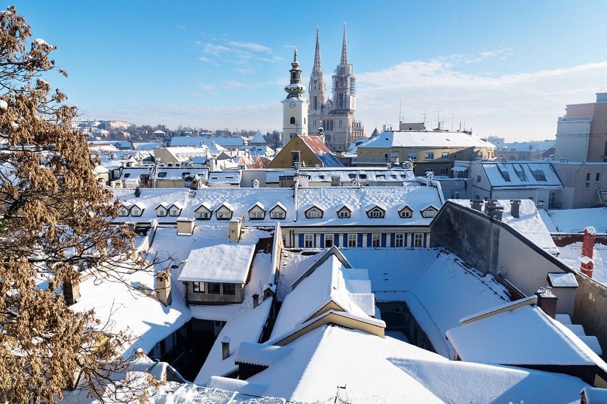 Snow-covered roofs in Zagreb underneath a bright blue sky