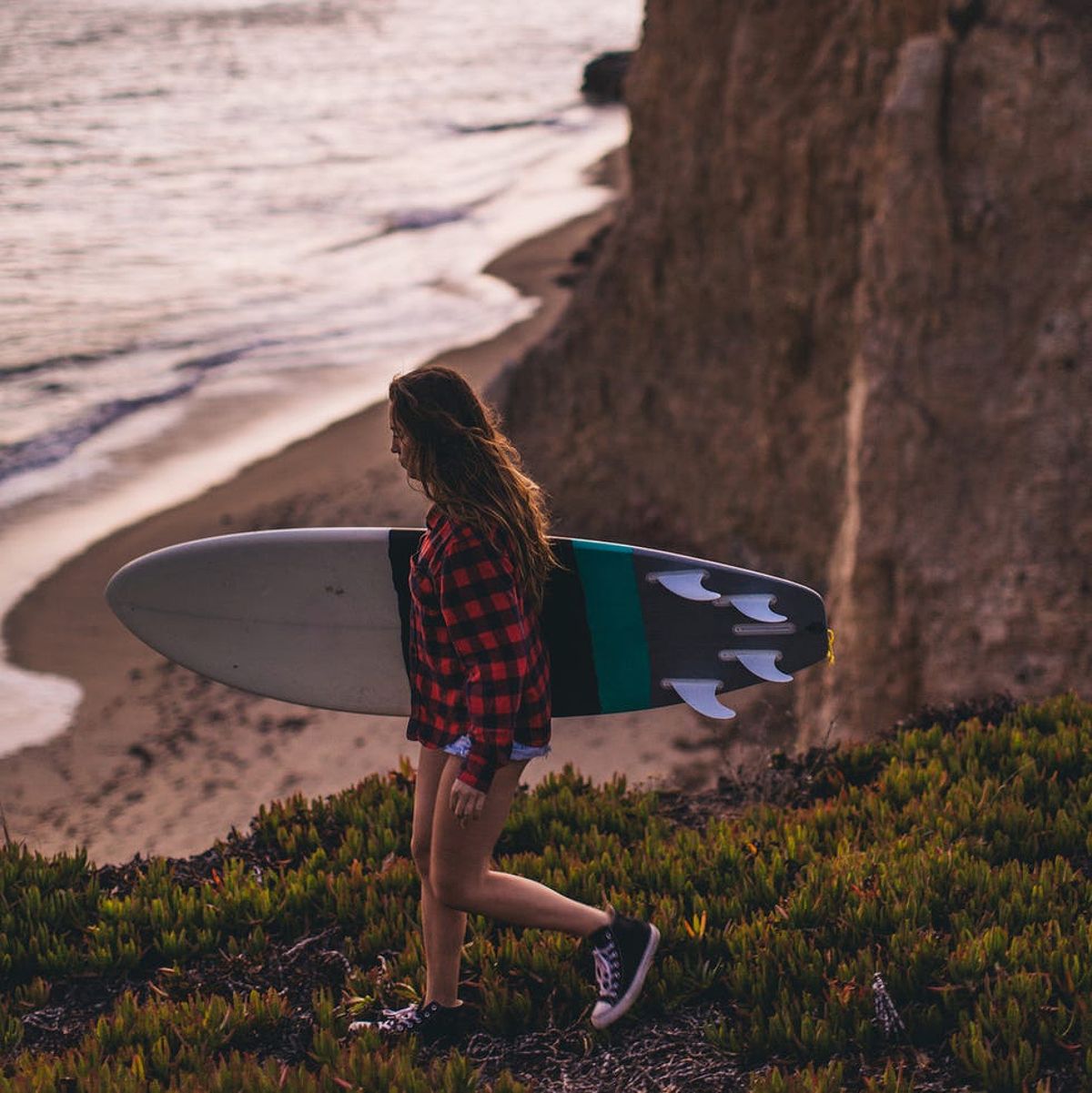 Surfer with surfboard on hill, Santa Cruz, California, USA