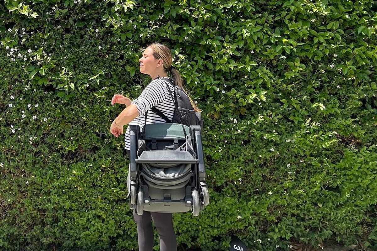 The author carrying the Joolz Aer+ travel stroller on her shoulder